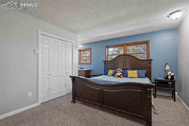 bedroom featuring light carpet, a textured ceiling, and a closet