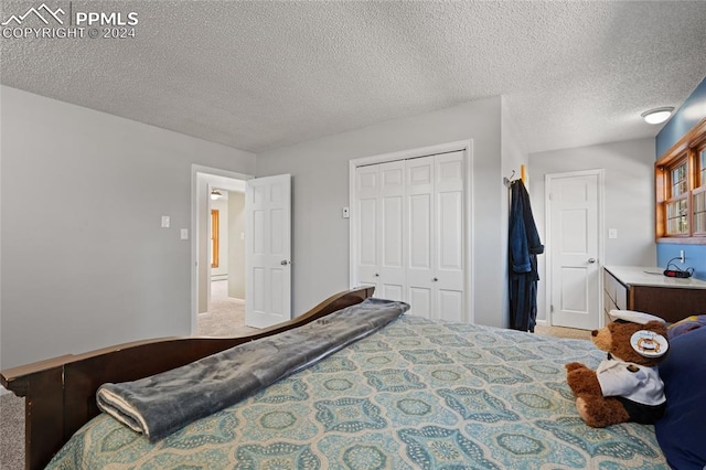 carpeted bedroom with a textured ceiling and a closet