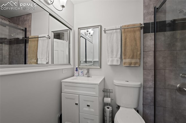 bathroom featuring vanity, toilet, and a shower with shower door