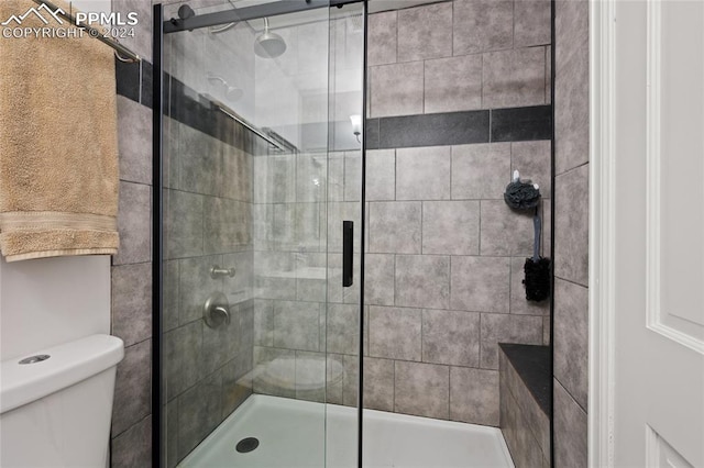 bathroom featuring toilet and an enclosed shower