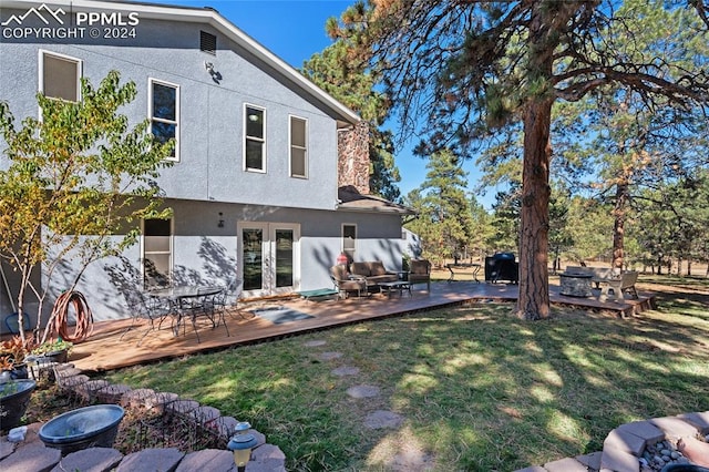 back of property with a wooden deck and a lawn