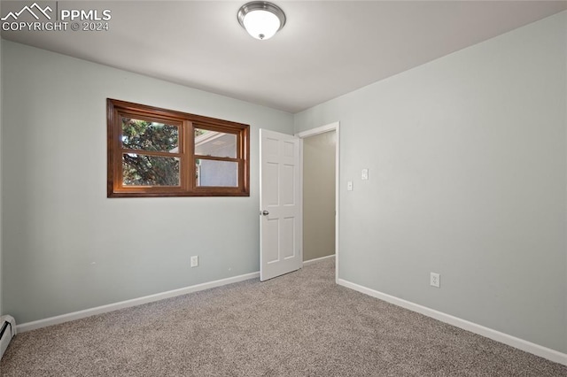 empty room with light carpet and baseboard heating