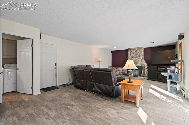 living room featuring washer / dryer, a textured ceiling, and hardwood / wood-style floors