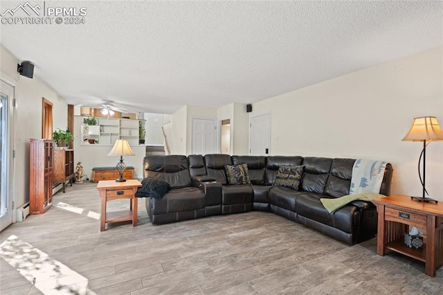 living room featuring a textured ceiling, wood-type flooring, and ceiling fan