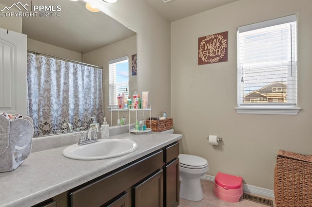 bathroom featuring vanity, toilet, and tile patterned flooring