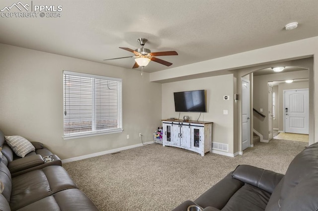 carpeted living room featuring a textured ceiling and ceiling fan