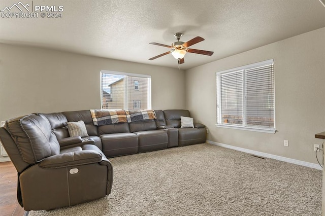 living room with carpet, ceiling fan, a textured ceiling, and a wealth of natural light