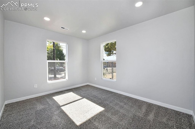 unfurnished room featuring dark carpet