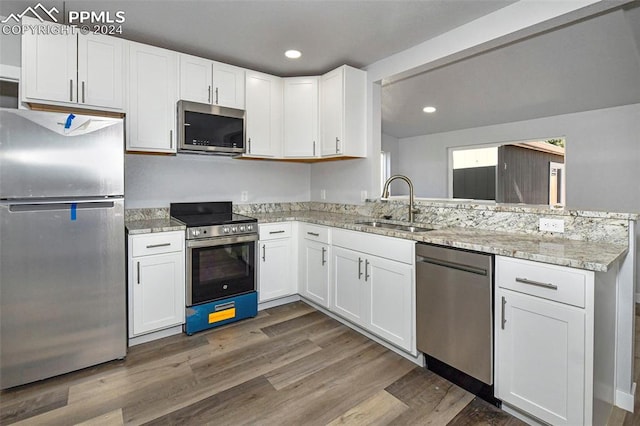 kitchen with stainless steel appliances, sink, dark hardwood / wood-style flooring, and white cabinets