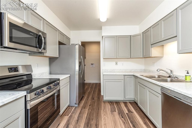 kitchen featuring appliances with stainless steel finishes, dark hardwood / wood-style floors, sink, and gray cabinets