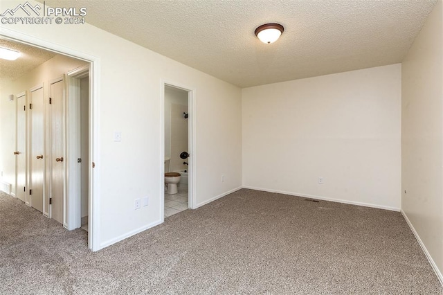 unfurnished room featuring carpet flooring and a textured ceiling