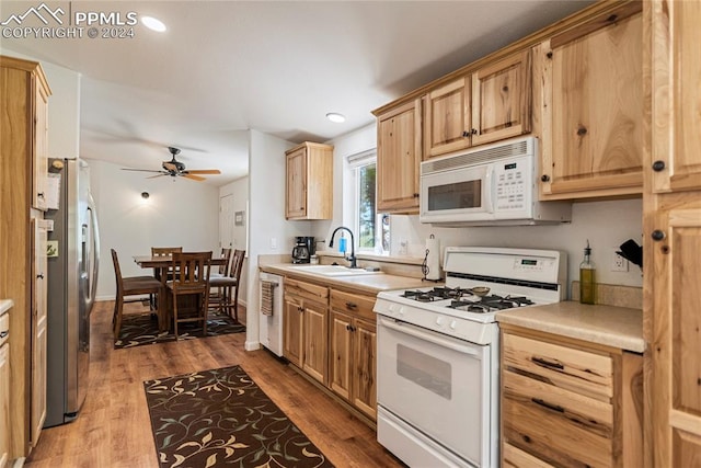 kitchen featuring light brown cabinets, hardwood / wood-style floors, ceiling fan, sink, and white appliances