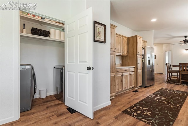 kitchen featuring ceiling fan, stainless steel refrigerator with ice dispenser, dark hardwood / wood-style floors, and washer / clothes dryer