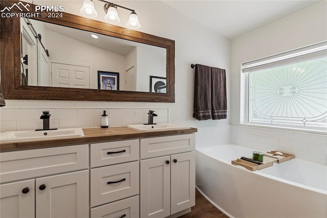 bathroom featuring a bathtub, backsplash, wood-type flooring, and vanity