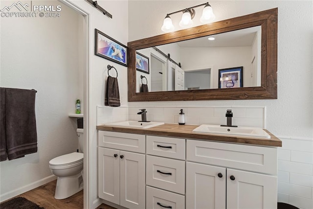 bathroom featuring tasteful backsplash, hardwood / wood-style floors, toilet, vaulted ceiling, and vanity