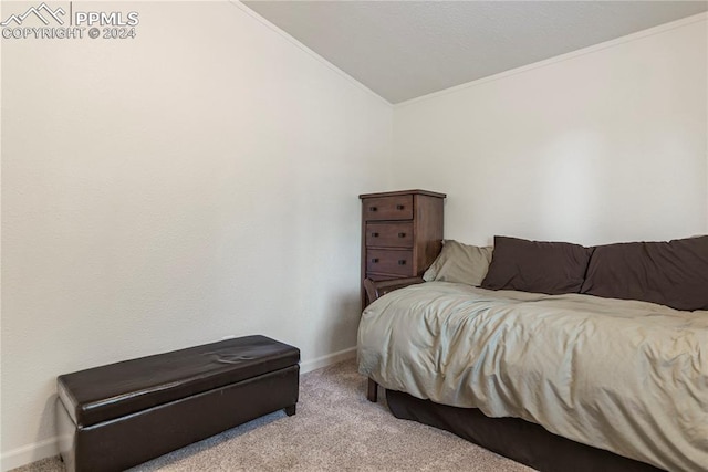 bedroom featuring light carpet, ornamental molding, and lofted ceiling