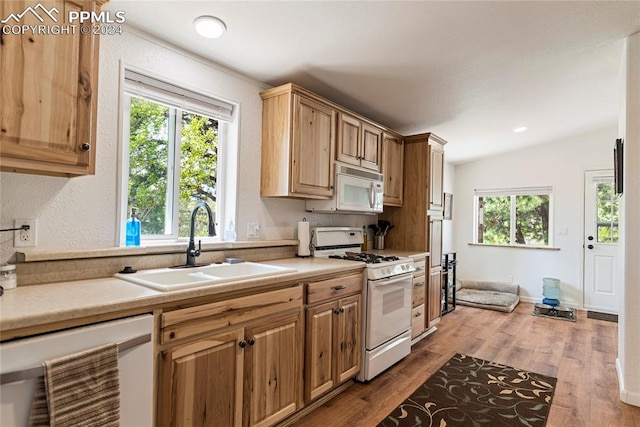 kitchen featuring white appliances, sink, vaulted ceiling, beverage cooler, and hardwood / wood-style flooring