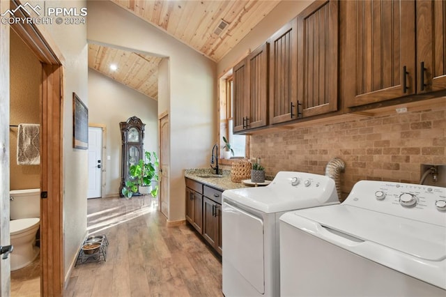 laundry room with wooden ceiling, light hardwood / wood-style floors, cabinets, sink, and independent washer and dryer