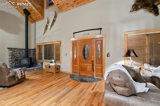 entryway featuring a wood stove, hardwood / wood-style floors, high vaulted ceiling, and wooden ceiling