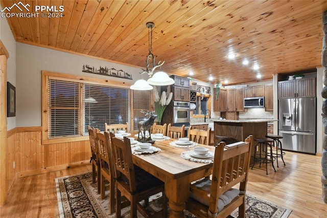 dining space featuring wooden ceiling, wood walls, and light wood-type flooring