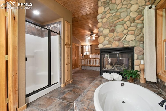 bathroom with a stone fireplace, vaulted ceiling, separate shower and tub, and wooden ceiling