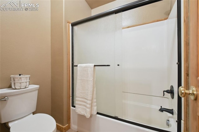 bathroom with enclosed tub / shower combo and toilet