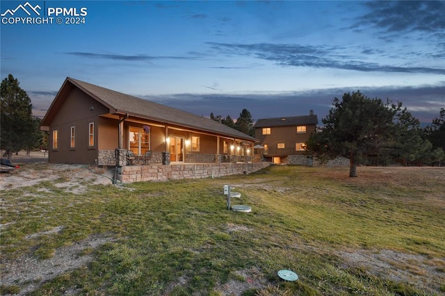 property exterior at dusk with a yard