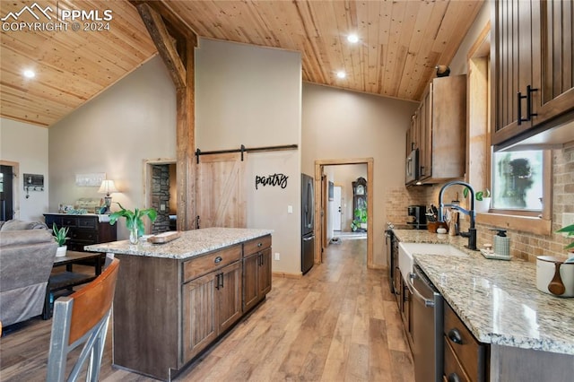 kitchen featuring light hardwood / wood-style floors, wood ceiling, a barn door, a kitchen island, and appliances with stainless steel finishes