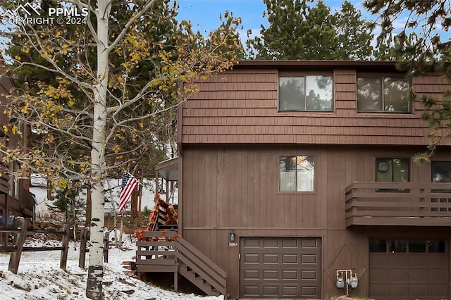 view of snow covered exterior with a garage