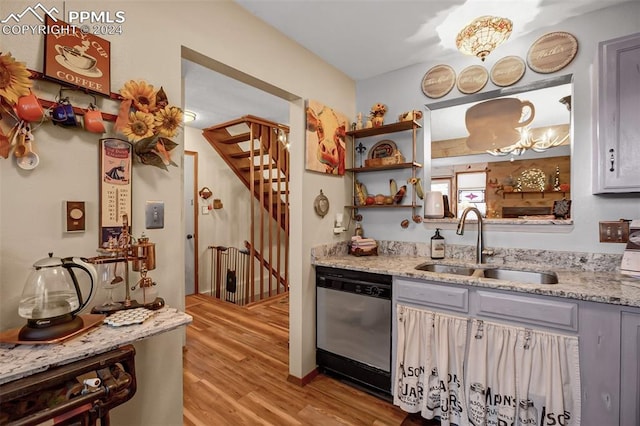 kitchen with dishwasher, light hardwood / wood-style flooring, sink, and light stone counters