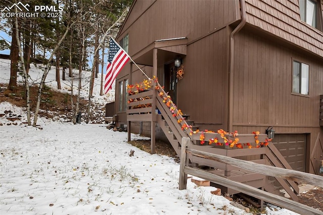 view of snow covered exterior featuring a garage