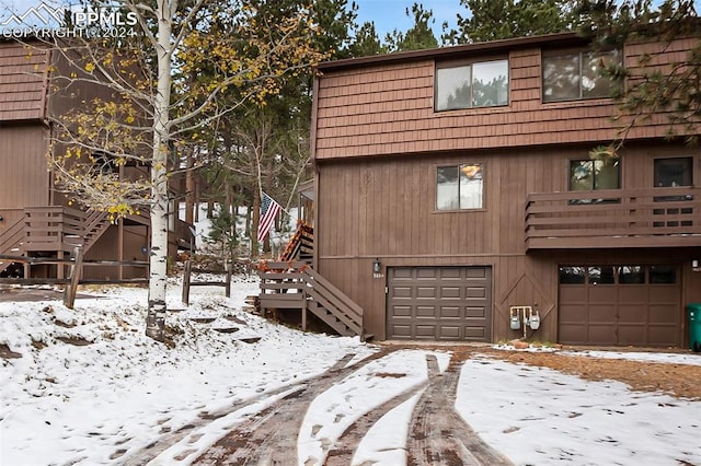 view of snow covered exterior featuring a garage