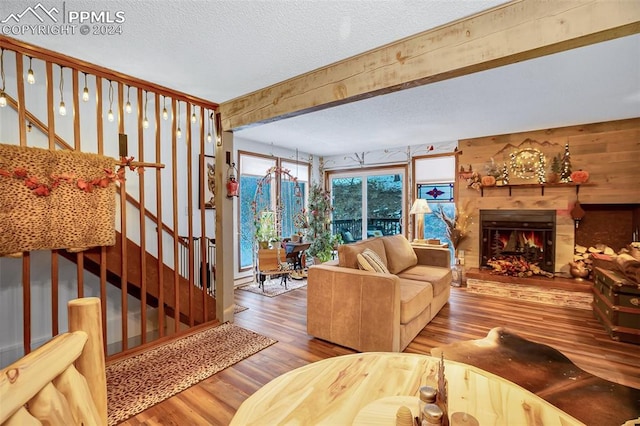 living room featuring beam ceiling, wood-type flooring, and a textured ceiling