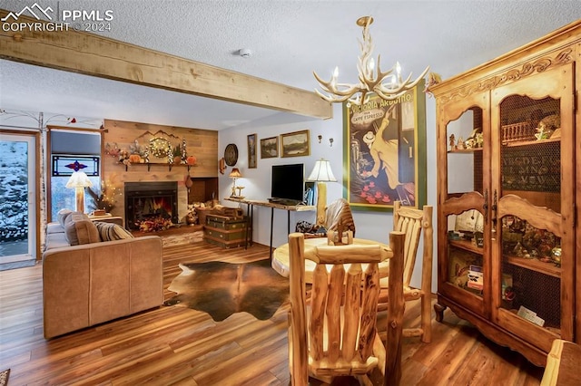 dining area featuring hardwood / wood-style floors, a notable chandelier, a textured ceiling, and beam ceiling