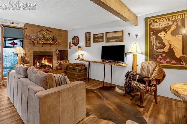 living room featuring a textured ceiling, light hardwood / wood-style flooring, wood walls, and beamed ceiling