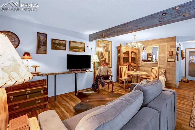 living room with hardwood / wood-style floors, wooden walls, a chandelier, and beam ceiling