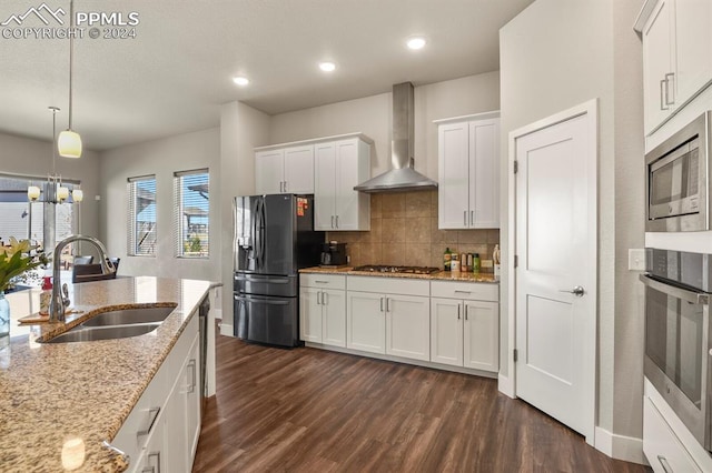 kitchen with wall chimney range hood, white cabinets, dark hardwood / wood-style flooring, stainless steel appliances, and sink