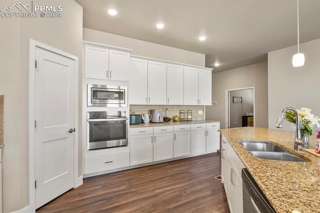 kitchen featuring white cabinets, light stone countertops, stainless steel appliances, and sink