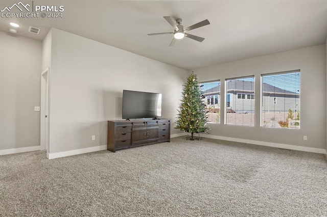 unfurnished living room with ceiling fan and carpet