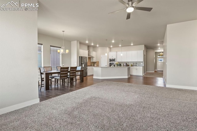 living room featuring dark hardwood / wood-style flooring and ceiling fan with notable chandelier