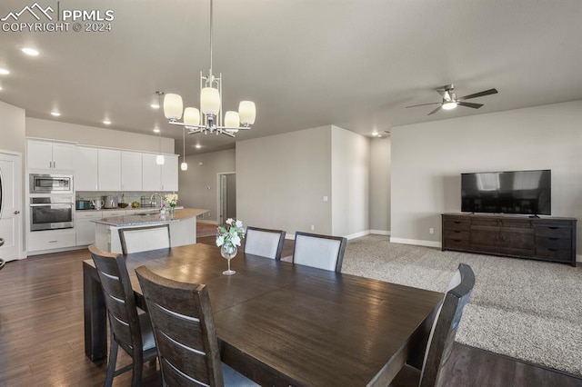 dining area featuring sink, dark hardwood / wood-style floors, and ceiling fan with notable chandelier