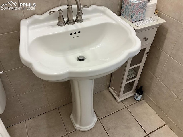 bathroom featuring tile patterned floors, sink, and tile walls