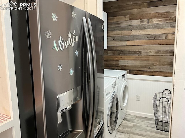 laundry area with separate washer and dryer and wooden walls