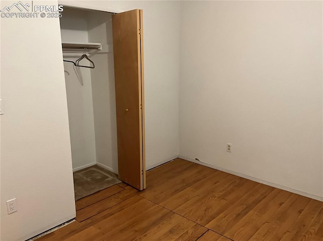 unfurnished bedroom with wood-type flooring and a closet