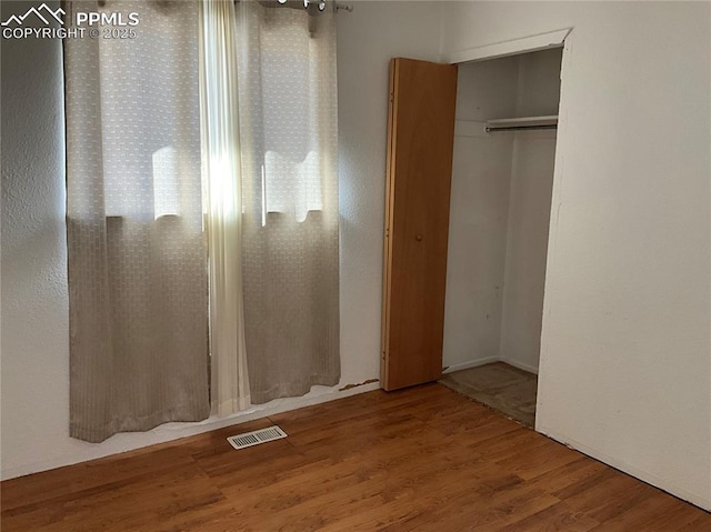 unfurnished bedroom with wood-type flooring and a closet