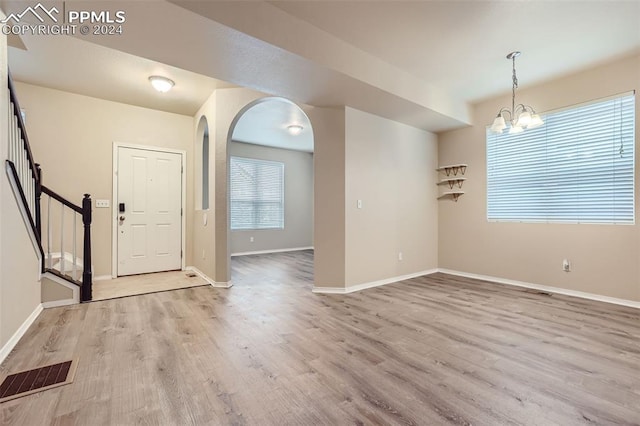 foyer entrance featuring an inviting chandelier and light hardwood / wood-style floors