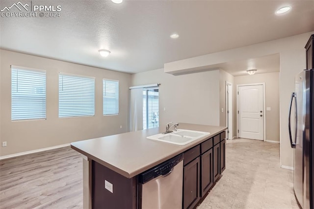 kitchen featuring sink, appliances with stainless steel finishes, dark brown cabinetry, and an island with sink