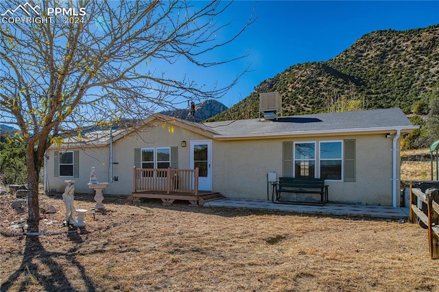 back of house with central air condition unit, a patio area, and a deck with mountain view