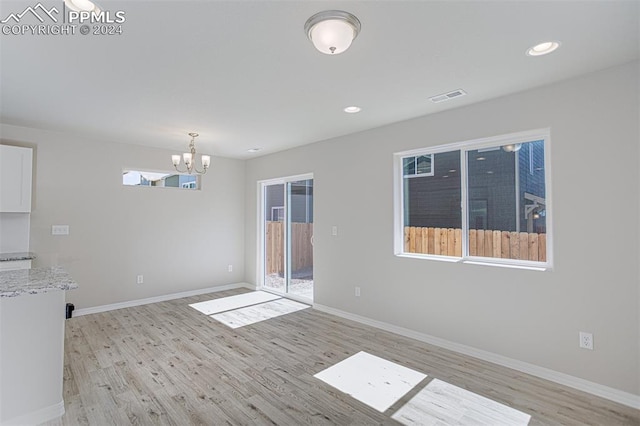 interior space featuring light hardwood / wood-style floors, a healthy amount of sunlight, and a chandelier