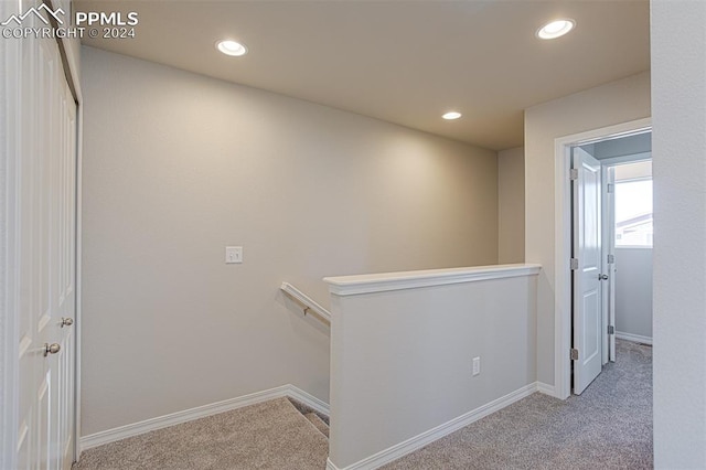 hallway with light colored carpet